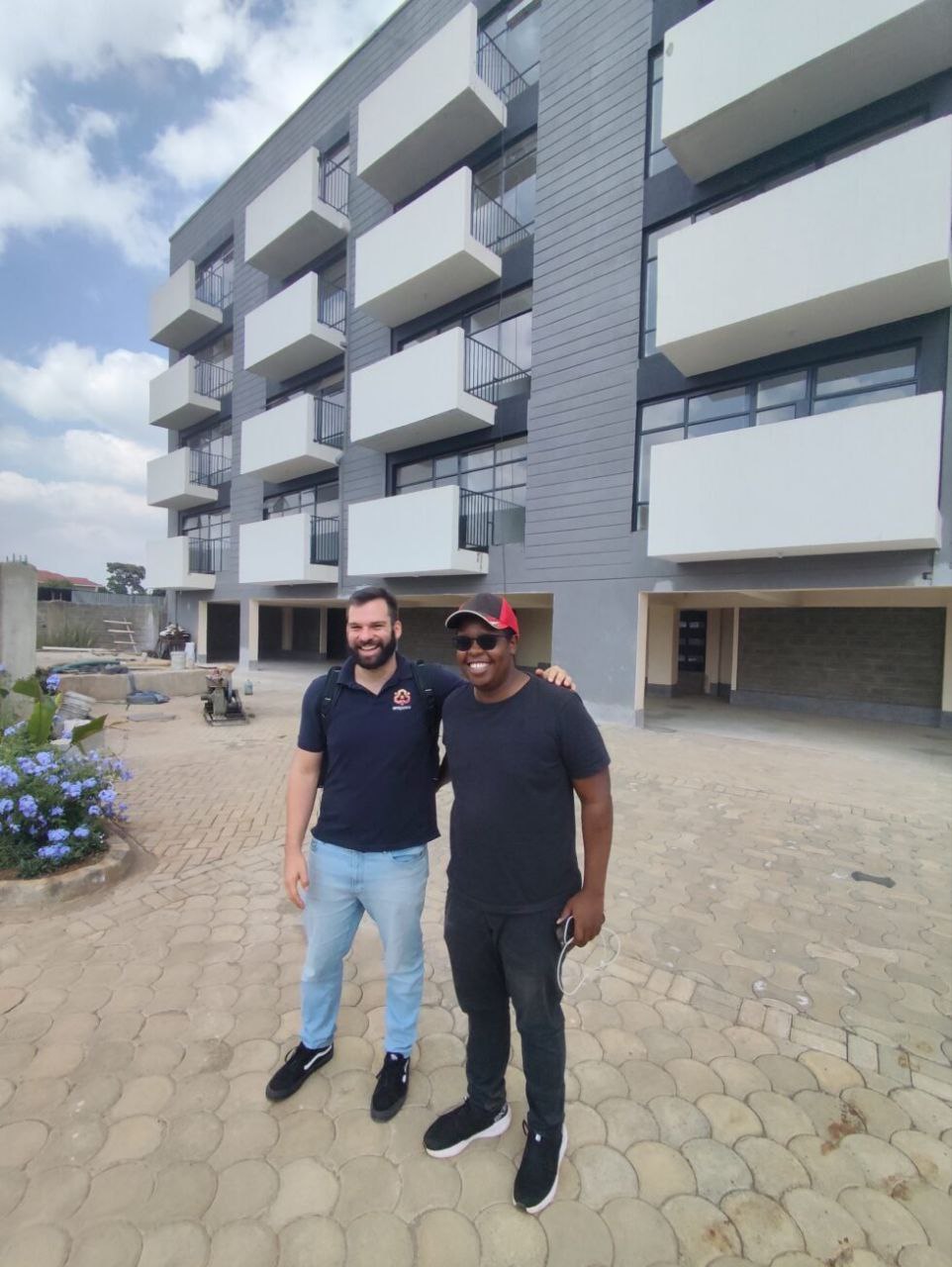 Empowa with developer partner in front of a completed BrownCap-style apartment building